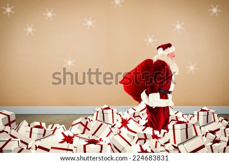 Santa walking on pile of gifts against room with wooden floor