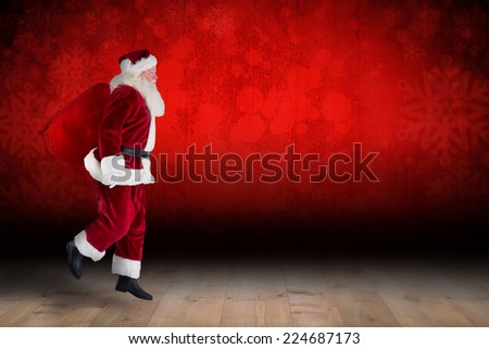 Santa claus carrying sack against snowflake wallpaper over floor boards
