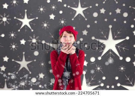 Woman blowing kiss to camera against snowflake wallpaper pattern