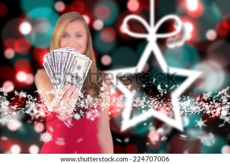 Pretty blonde showing wad of cash against blurred christmas background