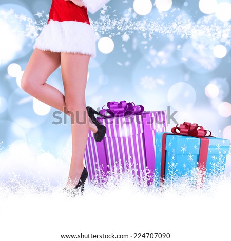 Festive womans legs in high heels against white glowing dots on blue