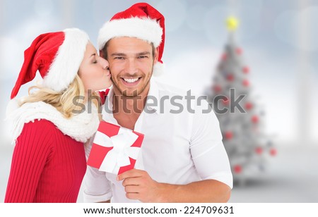 Young festive couple against blurry christmas tree in room