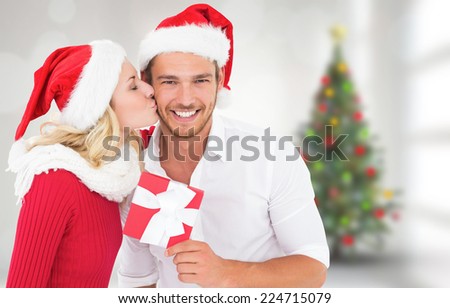 Young festive couple against blurry christmas tree in room