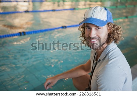 Portrait of a swimming coach by the pool smiling at leisure center