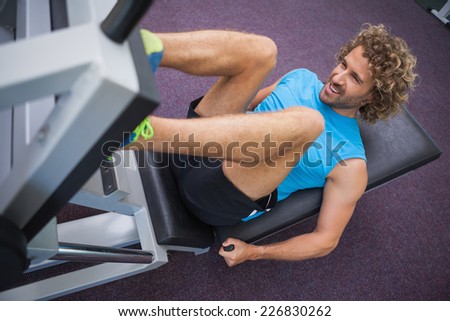 High angle view of young handsome man doing leg presses in the gym