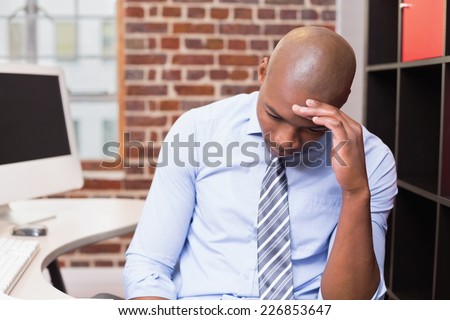 Young businessman sitting with head in hand in the office