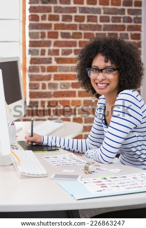 Portrait of smiling female photo editor using digitizer in the office