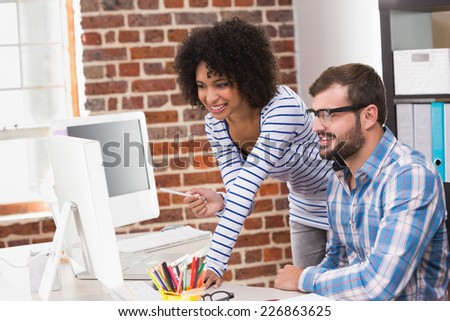 Portrait of two smiling photo editors using computer in the office