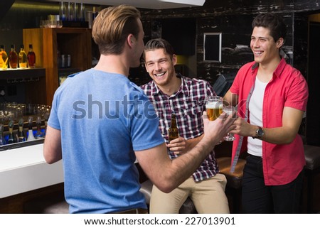 Young men drinking beer together at the bar