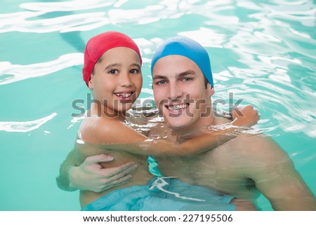 Cute little boy learning to swim with coach at the leisure center