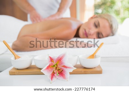 Side view of an attractive young woman receiving back massage at spa center