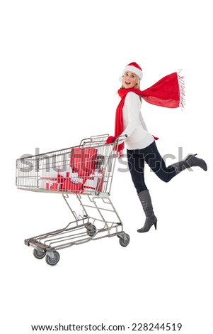 Festive blonde pushing trolley full of gifts on white background