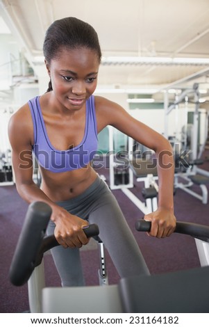 Fit woman working out on the exercise bike at the gym