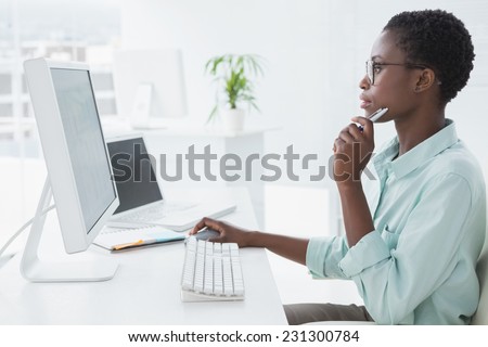 Focused businesswoman working at desk in creative office