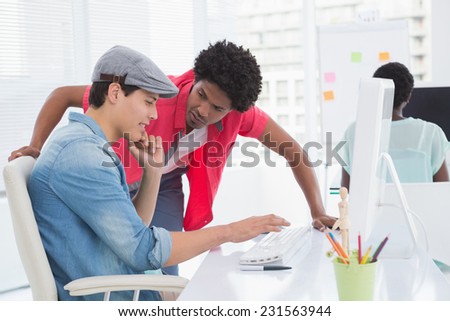Young creative man working at desk in creative office