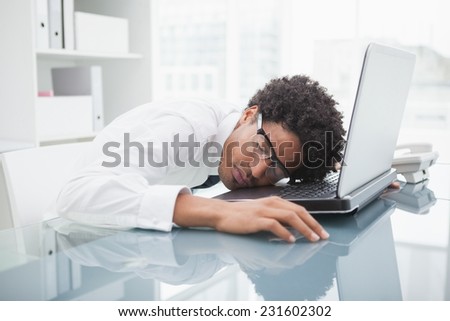Businessman with glasses sleeping on laptop in the office