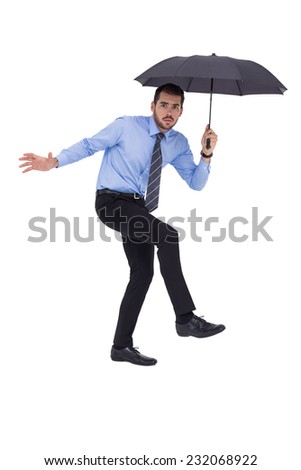 Anxious businessman under umbrella balancing on white background
