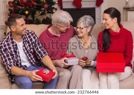 Happy family with gift on the couch at home in the living room