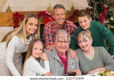 Happy extended family posing at christmas time at home in the living room