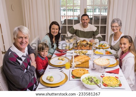 Extended family looking at camera at christmas time at home in the living room