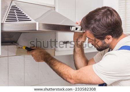 Handyman fixing the oven in the kitchen