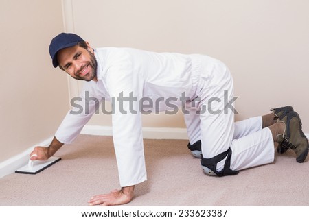 Handyman laying down a carpet in a new house