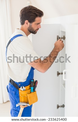 Handyman fixing a wardrobe in a new house