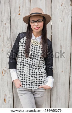 Pretty hipster posing for camera against bleached wooden planks