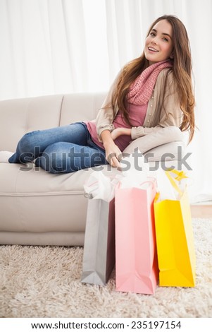 Pretty brunette with shopping bags at home in the living room