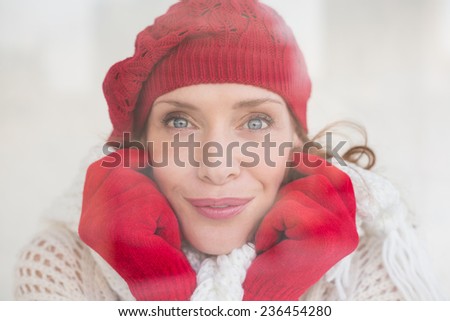 Pretty redhead in warm clothing seen through glass window