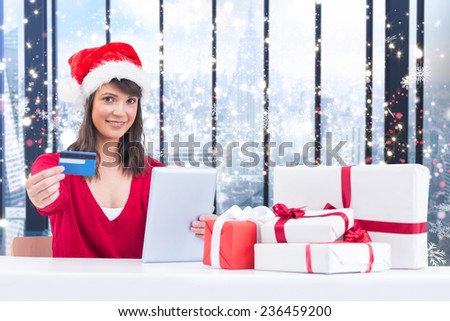 Festive brunette shopping online with tablet pc against glittering lights in room