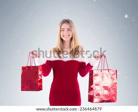 Pretty santa girl holding gift bags on vignette background