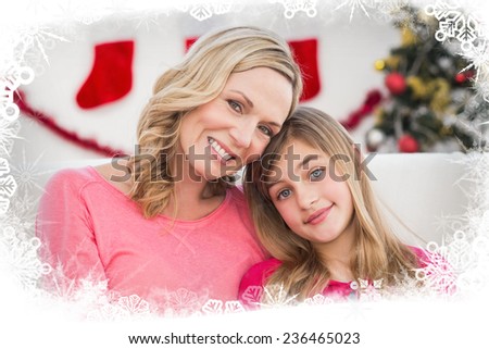 Festive mother and daughter smiling at camera against frost frame
