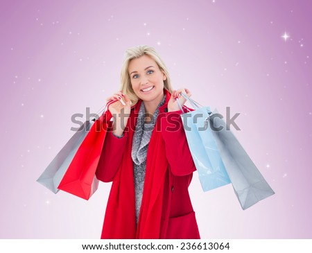 Blonde in winter clothes holding shopping bags on vignette background