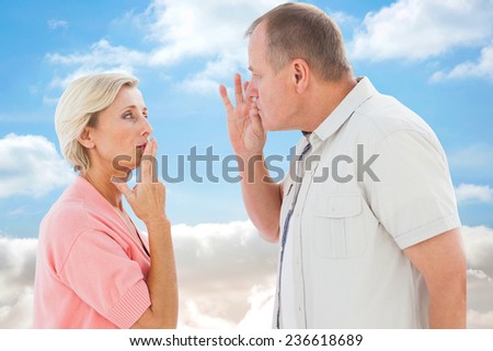 Older couple holding hands to mouth for silence against cloudy sky