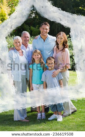 Smiling family and grandparents in the park against house outline in clouds