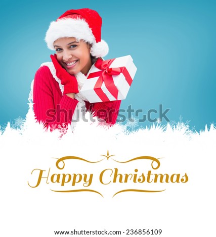 festive brunette holding gift against border