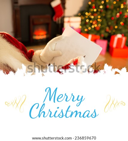 Composite image of santa checking his list against card
