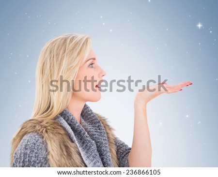 Blonde in winter clothes with hand out on vignette background