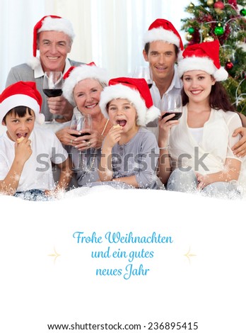 Family drinking wine and eating sweets in Christmas against border