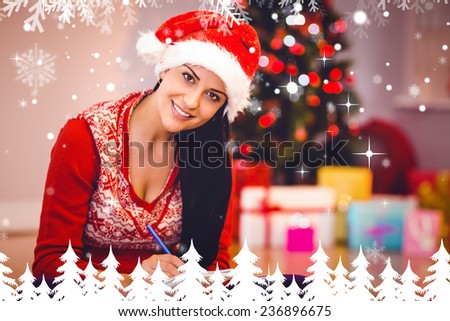 Festive brunette writing her list against fir tree forest and snowflakes