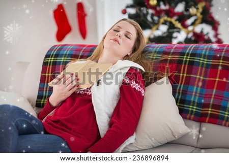 Young woman falling asleep while reading against snow falling