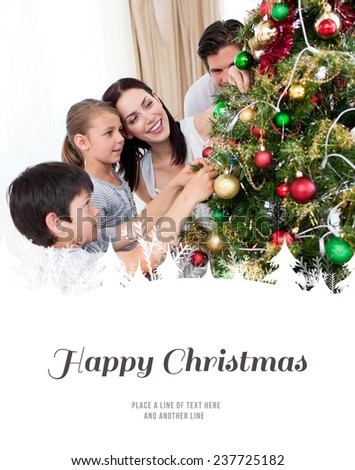 Happy family decorating a Christmas tree with boubles against happy christmas