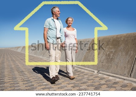 Happy senior couple walking on the pier against house outline