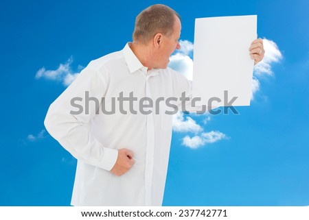 Angry man shouting at piece of paper against cloudy sky