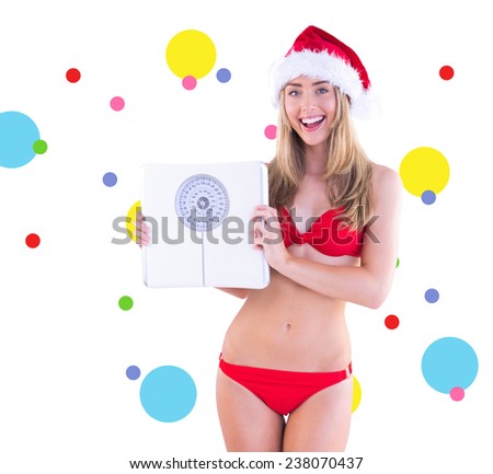 Festive fit blonde in red bikini showing scales against dot pattern