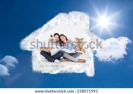 man and woman holding house plans against bright blue sky with clouds