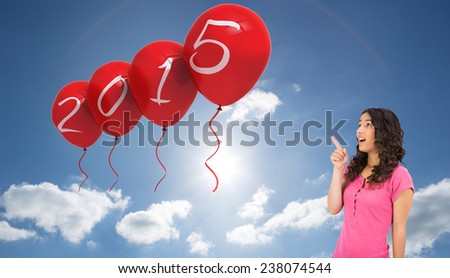 Surprised brown haired woman pointing out against cloudy sky with sunshine