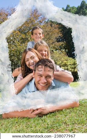 Family members lying on each other against house outline in clouds