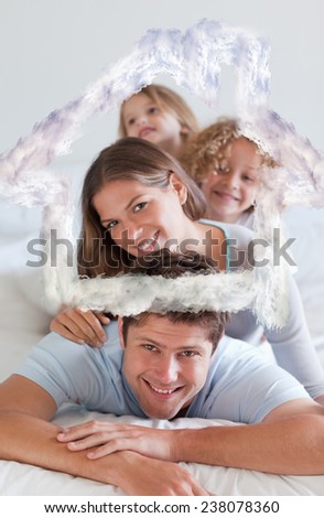 Portrait of a joyful family lying on each other against house outline in clouds